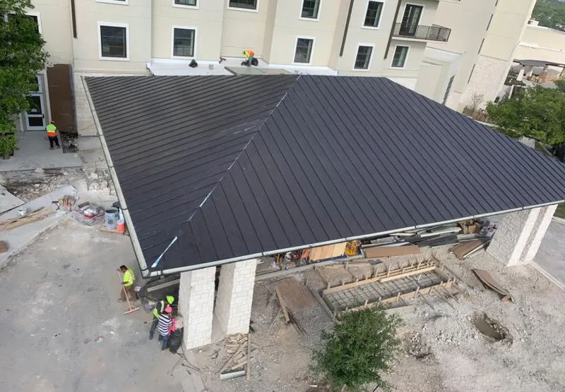 Metal roofing installation team working on a commercial building in Bangor